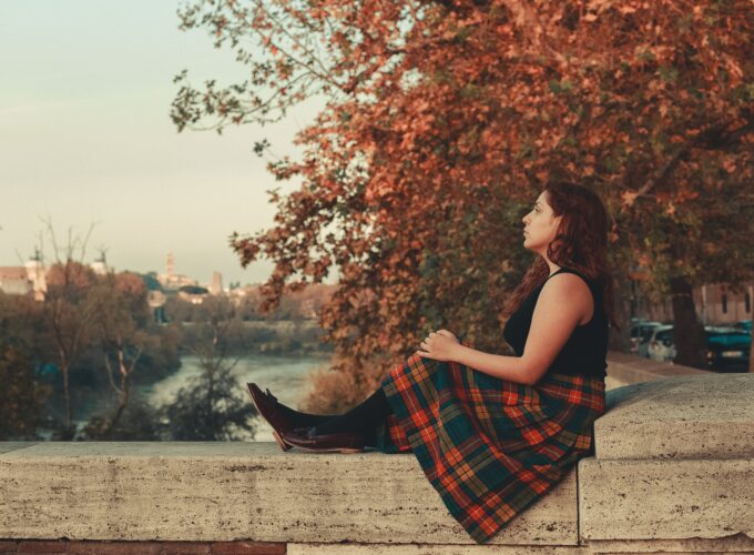 Un femme médite en automne au bord d'un canal.
