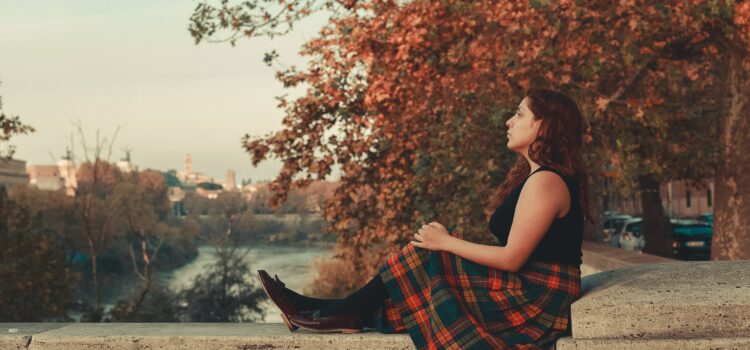 Un femme médite en automne au bord d'un canal.