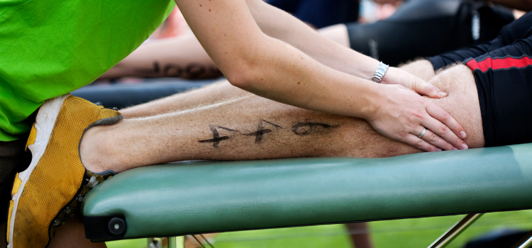 Un sportif reçoit un massage après une compétition.