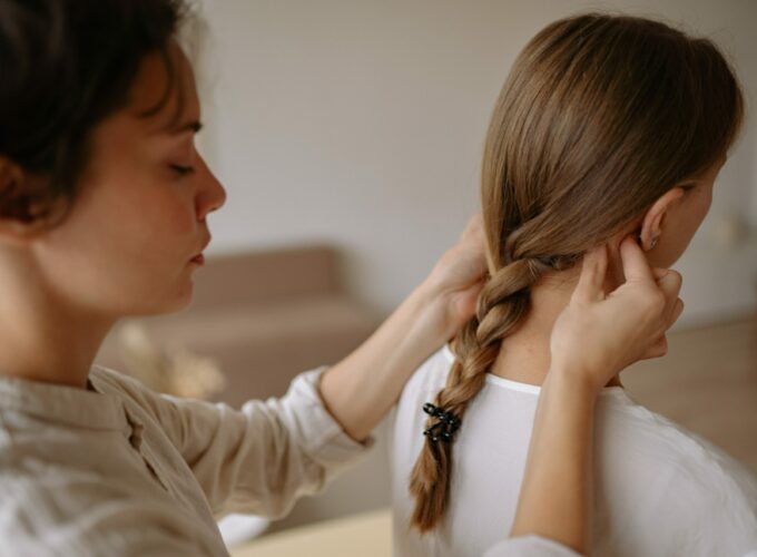 Une massothérapeute effectue des « pincer-rouler » de chaque côté du cou d’une jeune cliente