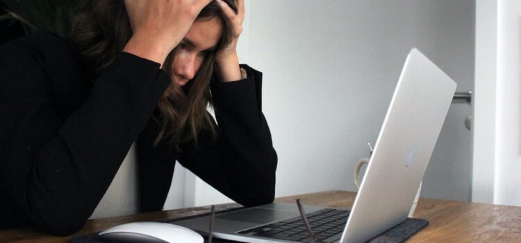 Une employée derrière son portable submergée par le stress.